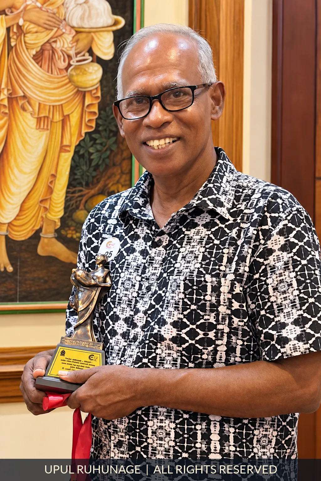 Upul Ruhunage holding an art award